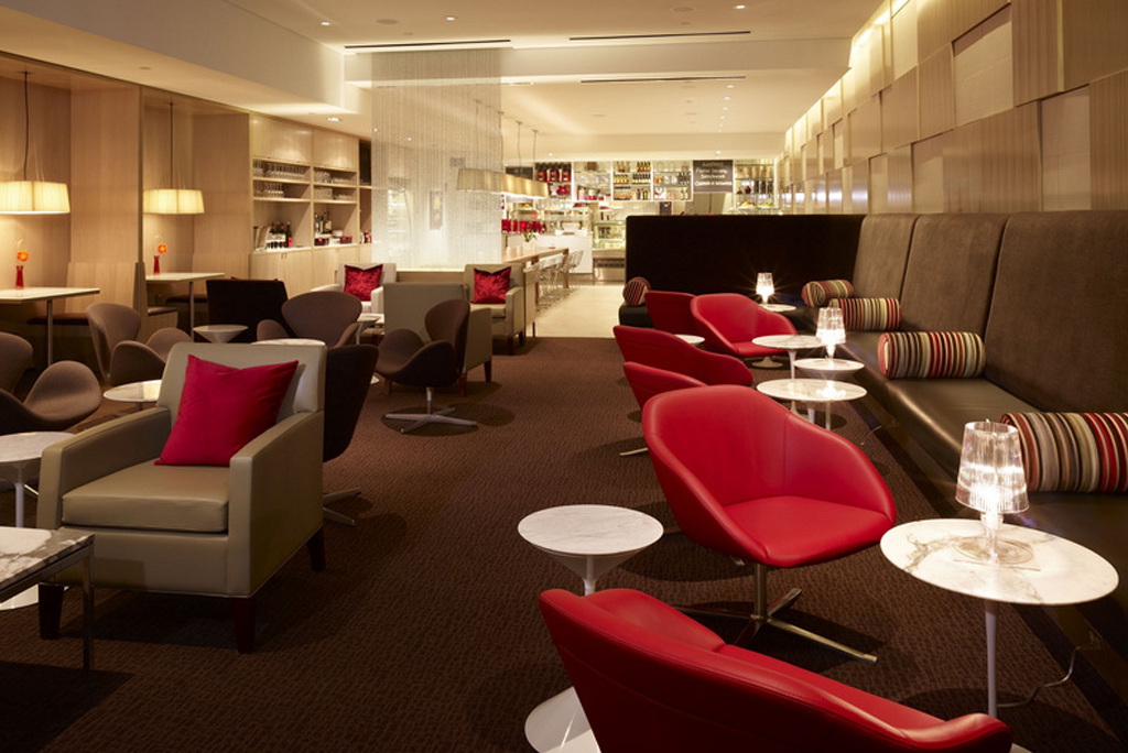 inside a lounge with red chairs and modern bar