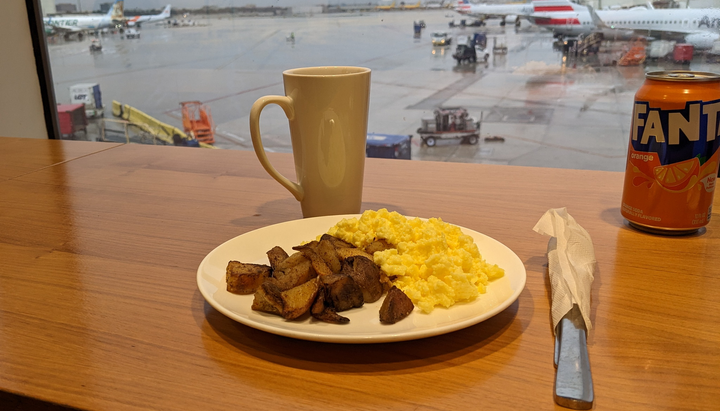 breakfast eggs, potatoes, coffee with a view of parked airplanes at gates