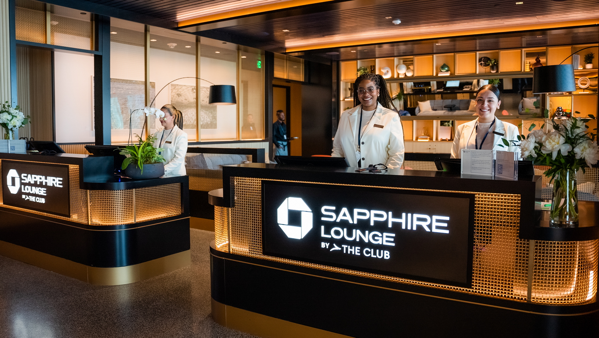Front desk at Chase Sapphire Lounge with two employees waiting to check you in.