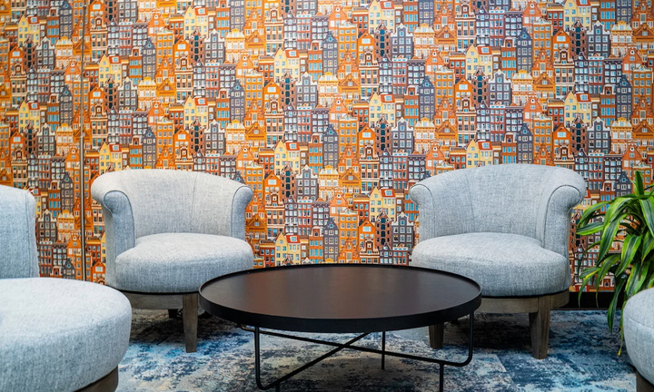 seating area with Dutch house wallpaper in background.
