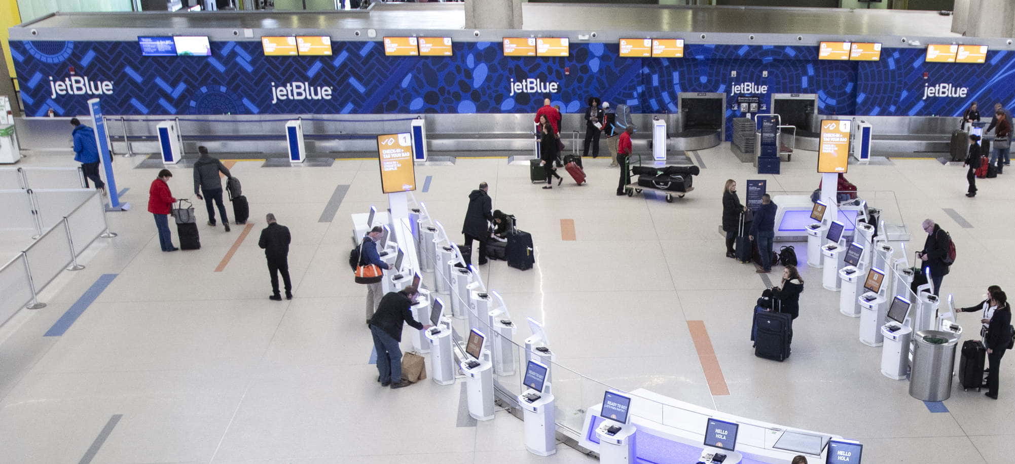 People checking baggage and getting boarding passes at airport.