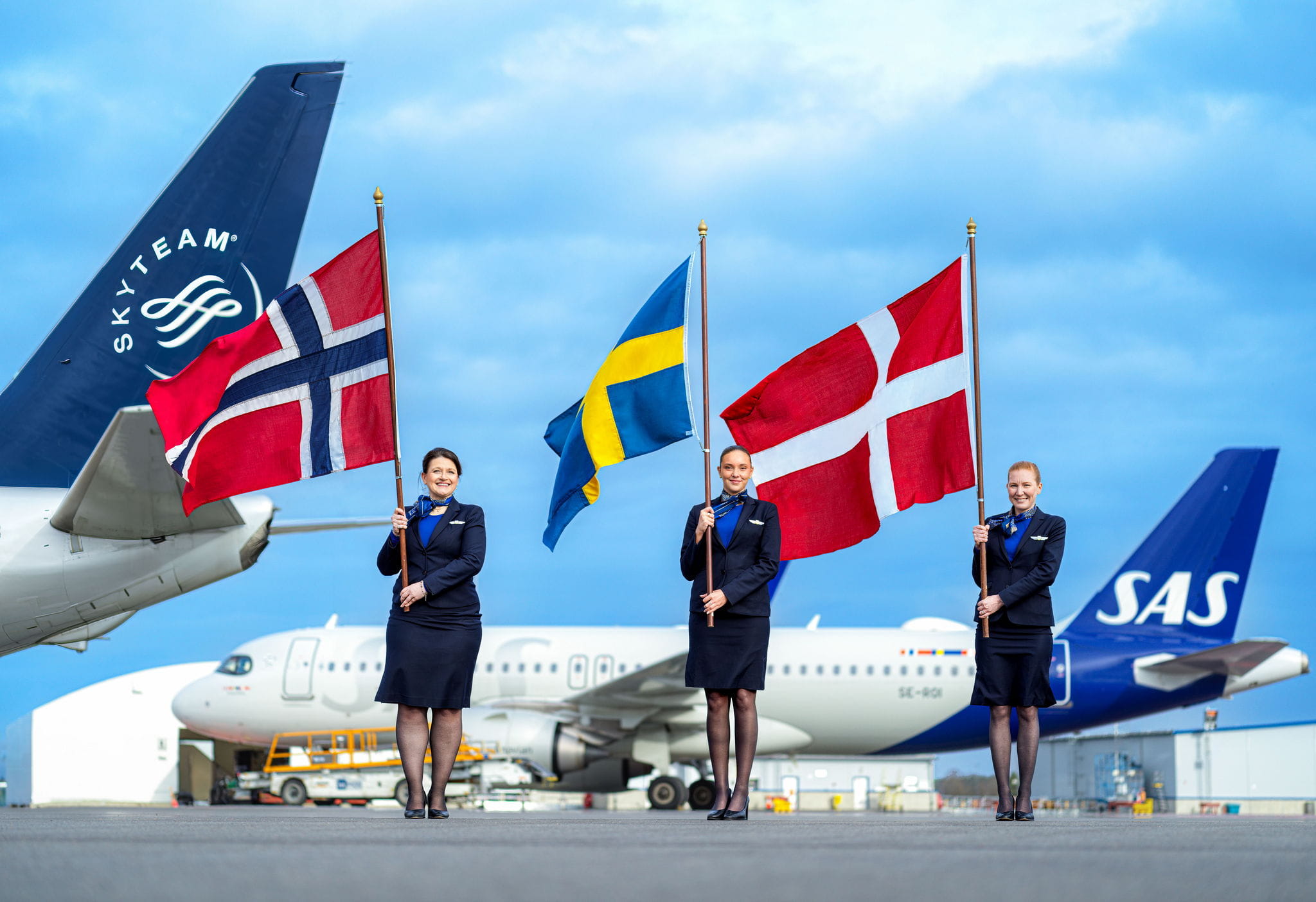 SkyTeam and SAS airplane tails, with employees holding flags.