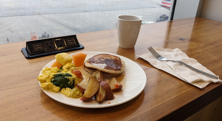 breakfast plate with pancakes, eggs and potatoes - view of runway in background.