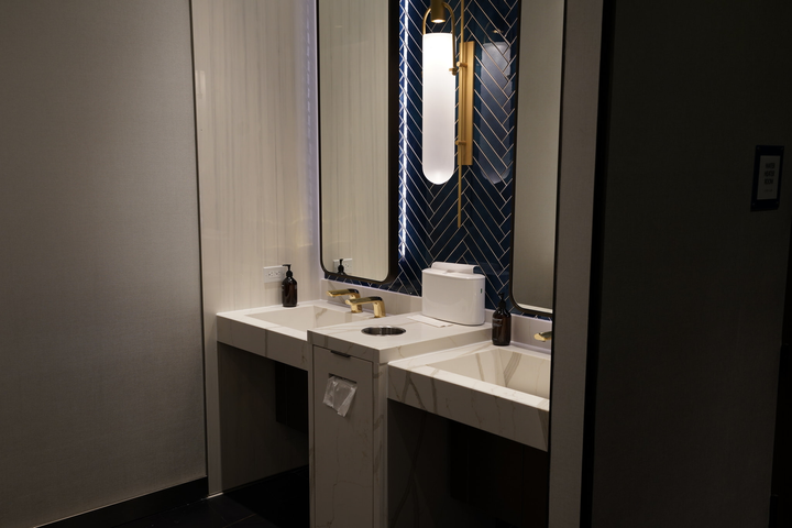 marble sink area with soap and windows.