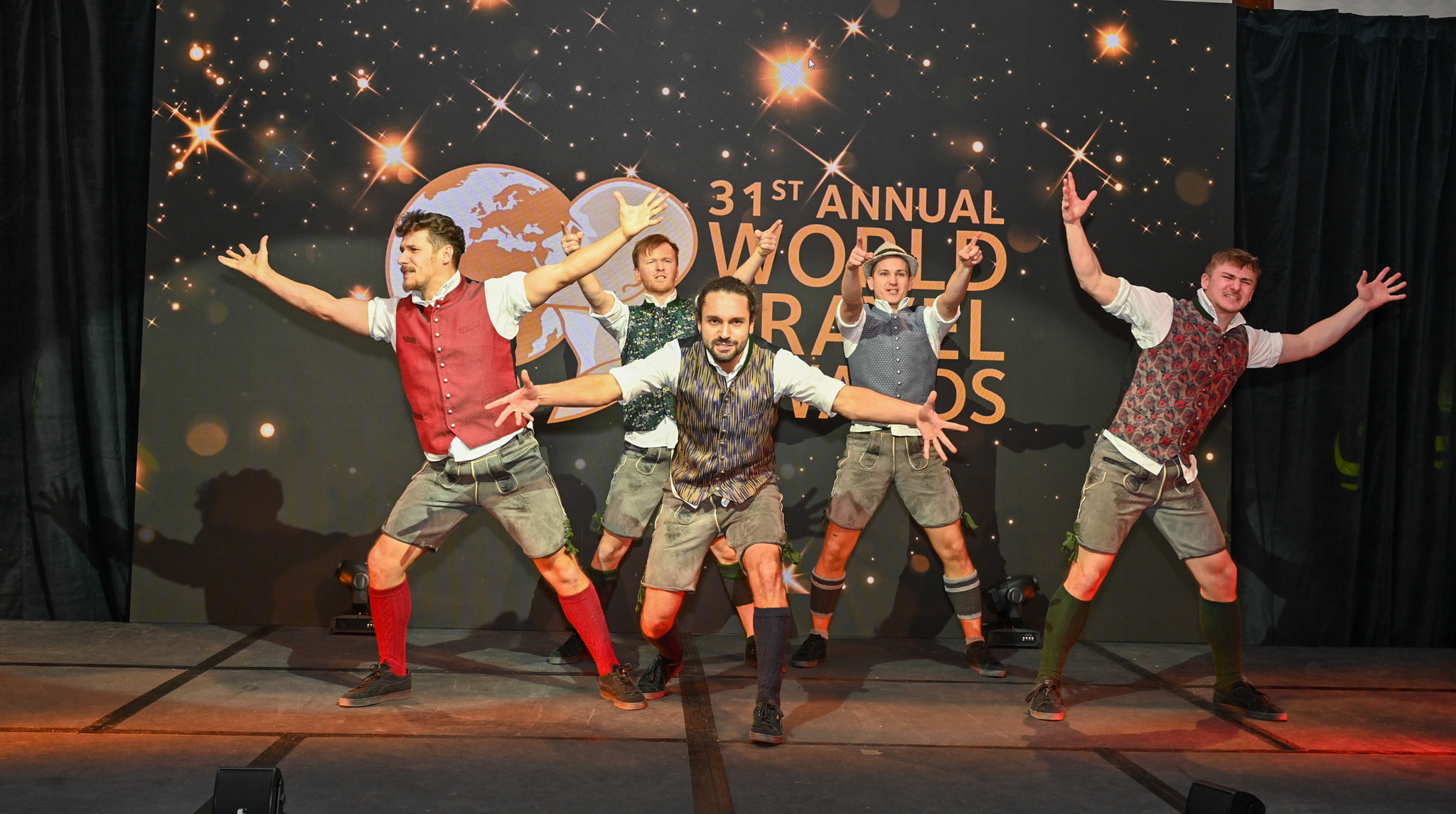 people standing on a stage with their trophies during award ceremony.