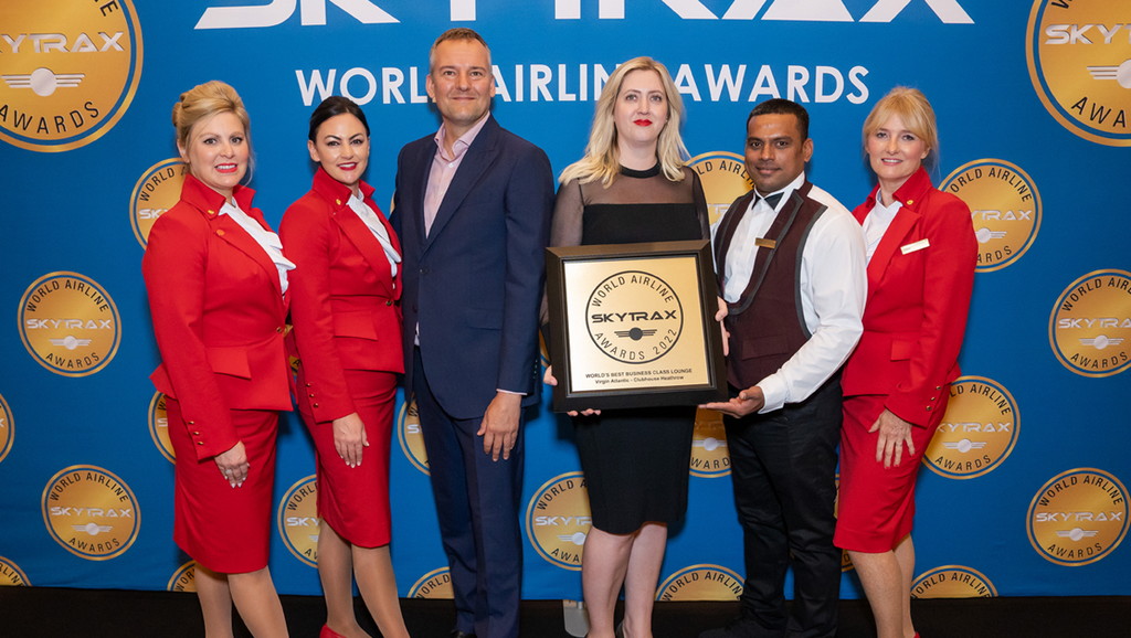 people posing with award for best business class lounge