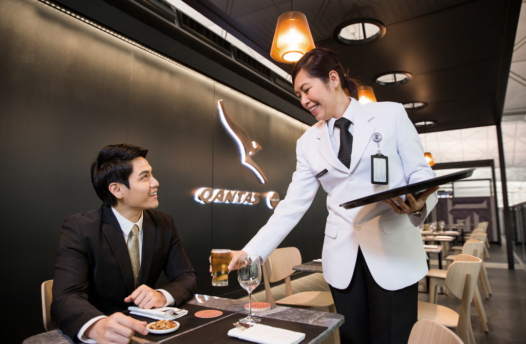 person serving drink at Qantas Lounge