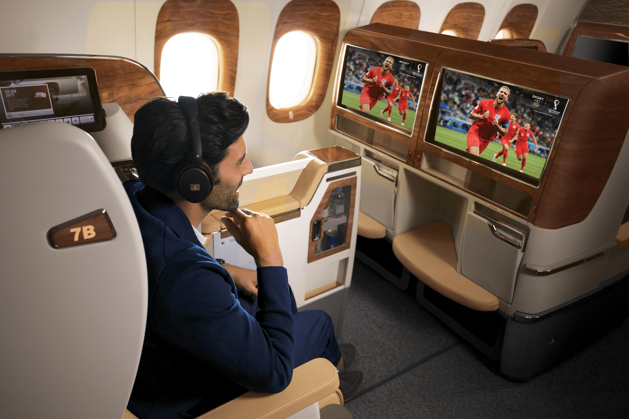 man onboard an emirates plane watching World Cup
