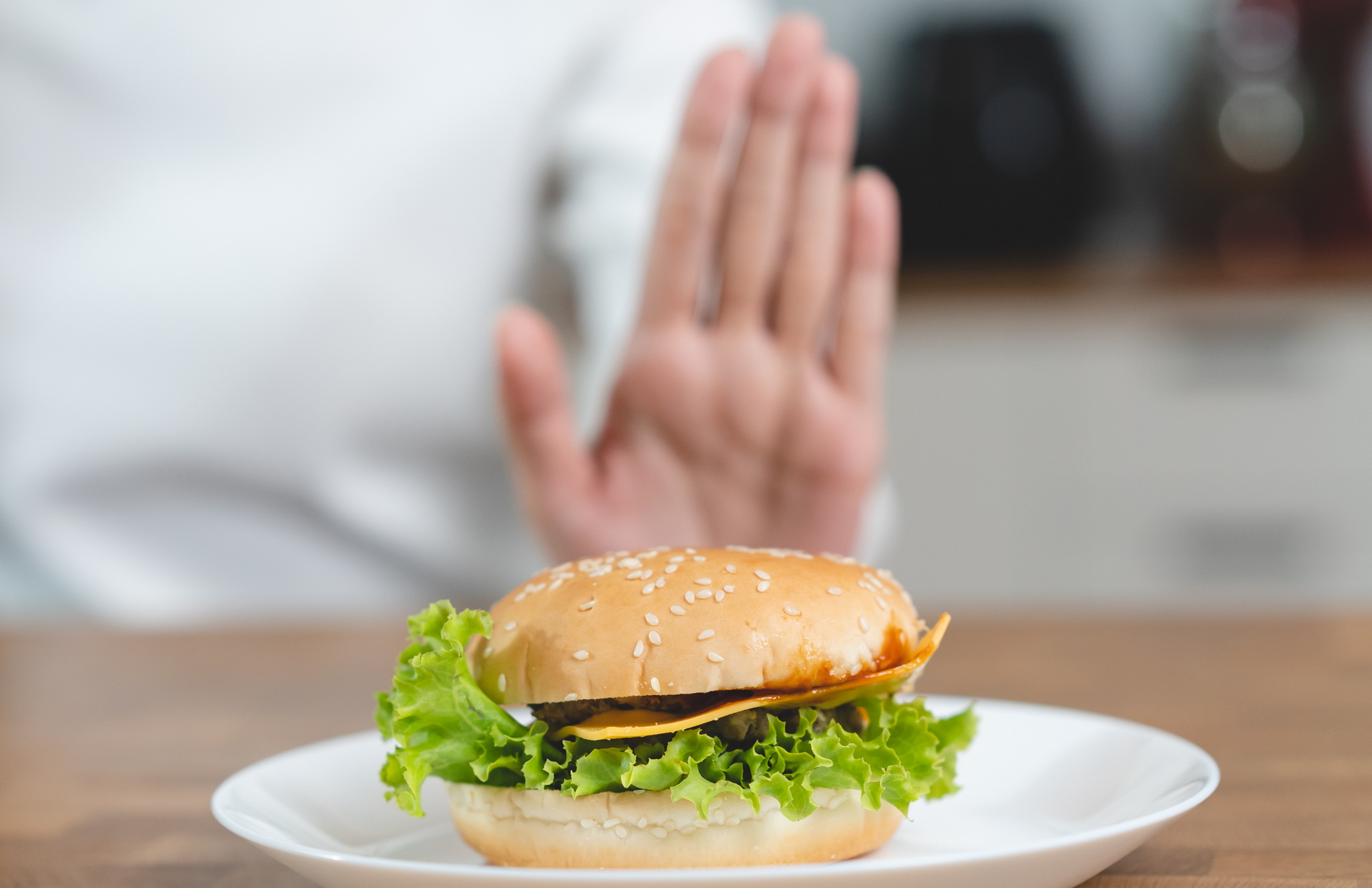 palm of hand indicating stop with a burger