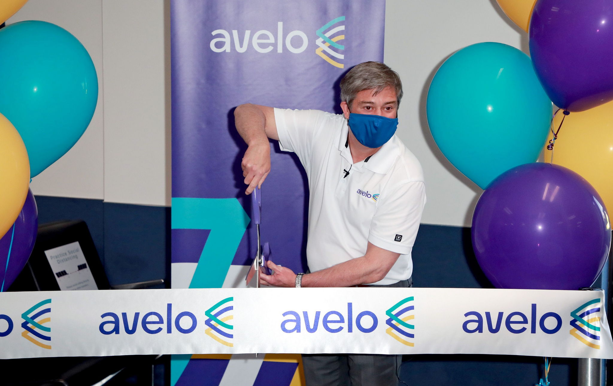 employee cutting ribbon for grand opening of Avelo Airlines
